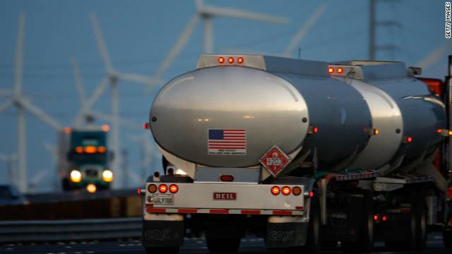 Emissions-producing diesel trucks pass non-polluting wind turbines along Interstate 10 in Banning, California.